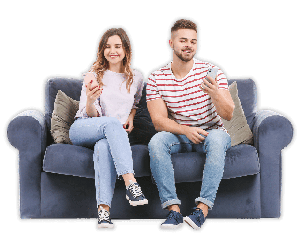 donna e uomo seduti sul divano che guardano il cellulare e sorridono